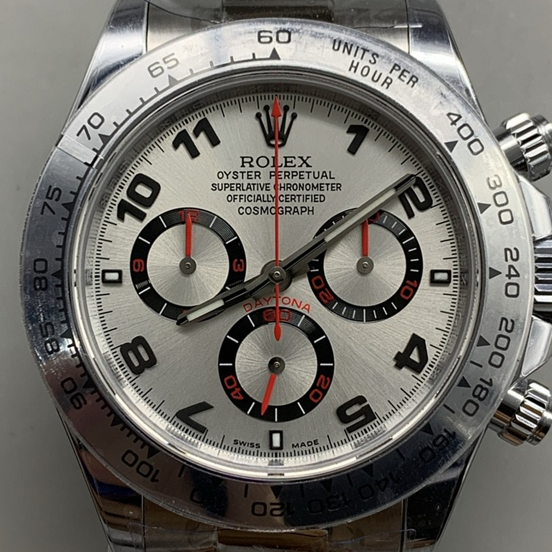 S002 · Camera geometry corrected. Image rotated approximately 17.5° clockwise at the dial centre; perspective and unequal image scaling normalized to a circular dial reference using isolated printed minute strokes. Recentered and resampled to 1900 × 1900 pixels. No correction for crystal refraction or raised bezel/hand geometry. Extended rays are visual dial references only; they do not correct or measure the raised bezel.