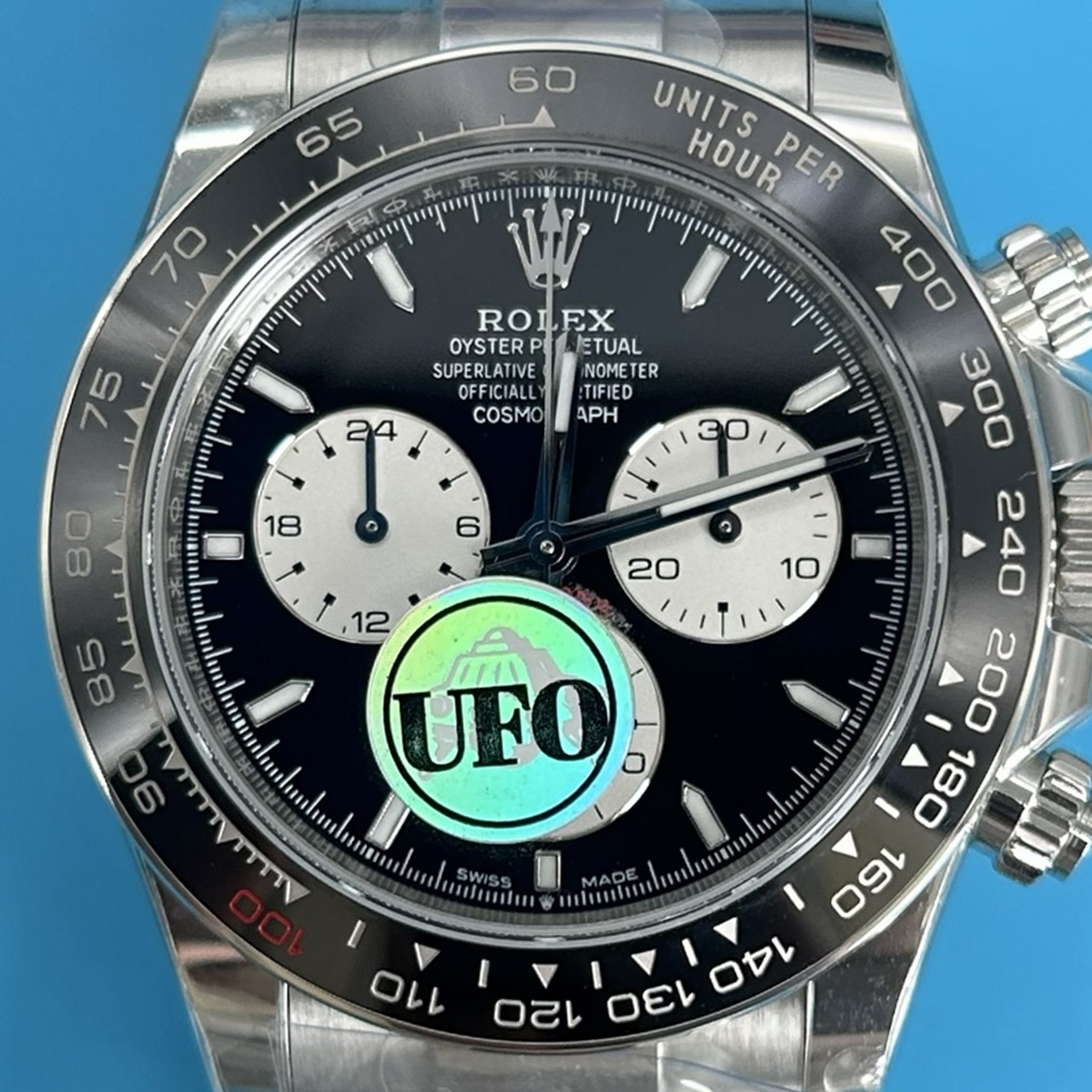 S003 · Camera geometry corrected. Image rotated approximately 0.5° clockwise at the dial centre; perspective and unequal image scaling normalized to a circular dial reference using isolated printed minute strokes. Recentered and resampled to 1900 × 1900 pixels. No correction for crystal refraction or raised bezel/hand geometry. Extended rays are visual dial references only; they do not correct or measure the raised bezel.