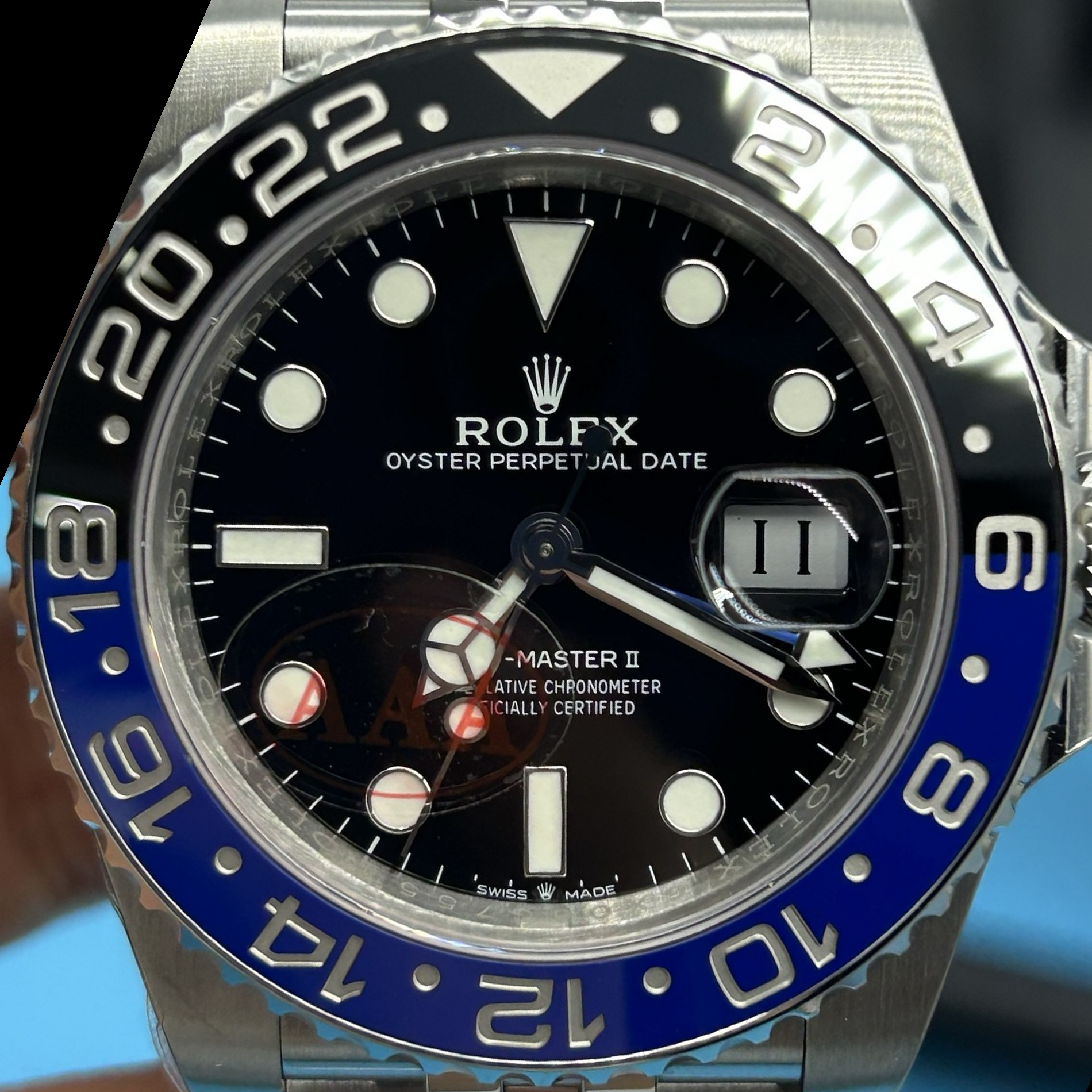 S009 · Camera geometry corrected. Image rotated approximately 23.4° clockwise at the dial centre; perspective and unequal image scaling normalized to a circular dial reference using isolated printed minute strokes. Recentered and resampled to 1900 × 1900 pixels. No correction for crystal refraction or raised bezel/hand geometry. Extended rays are visual dial references only; they do not correct or measure the raised bezel.